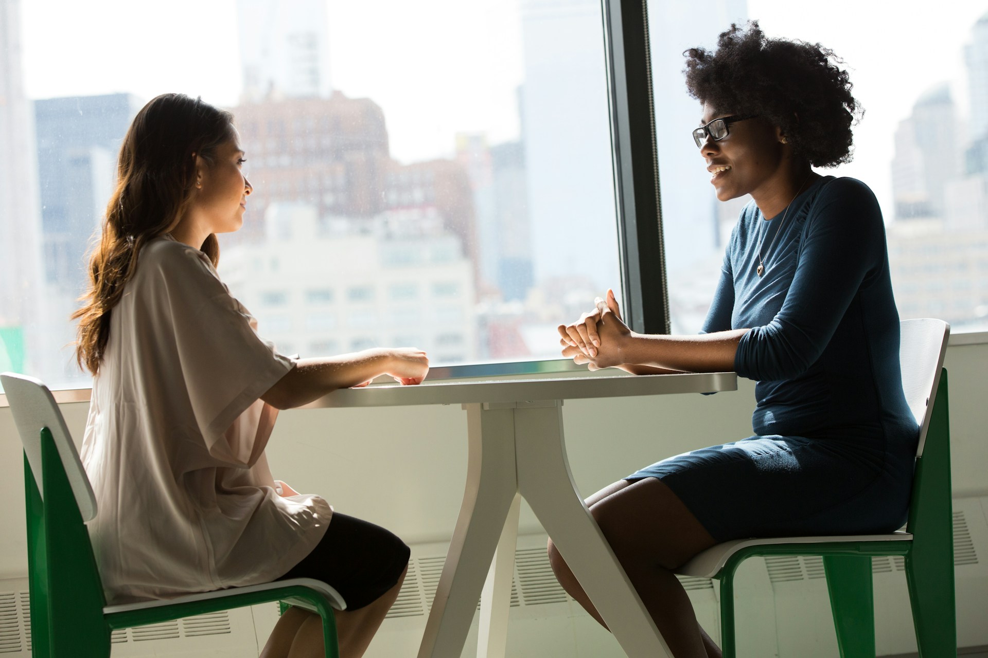 image of two women sitting at table across from each other