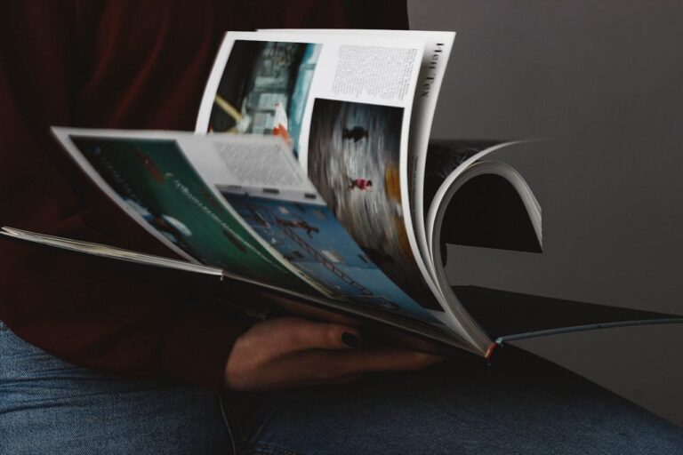 person flips through magazine pages